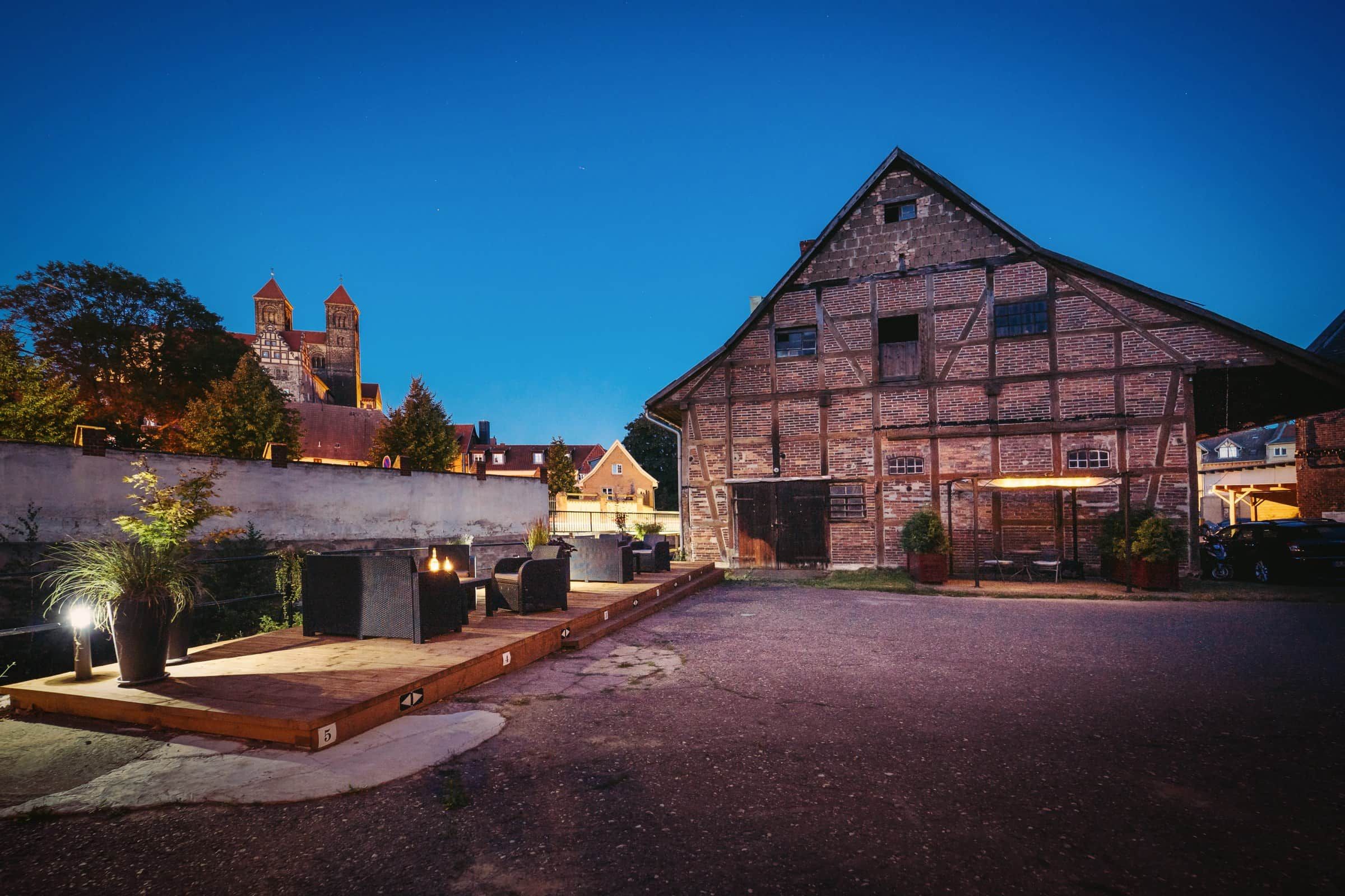 Un bâtiment historique doté d’une vaste cour intérieure, d’une structure traditionnelle en briques et d’une tour qui se profile à l’arrière-plan.