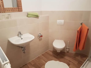 Ein Badezimmer mit Waschbecken, Toilette und Dusche.