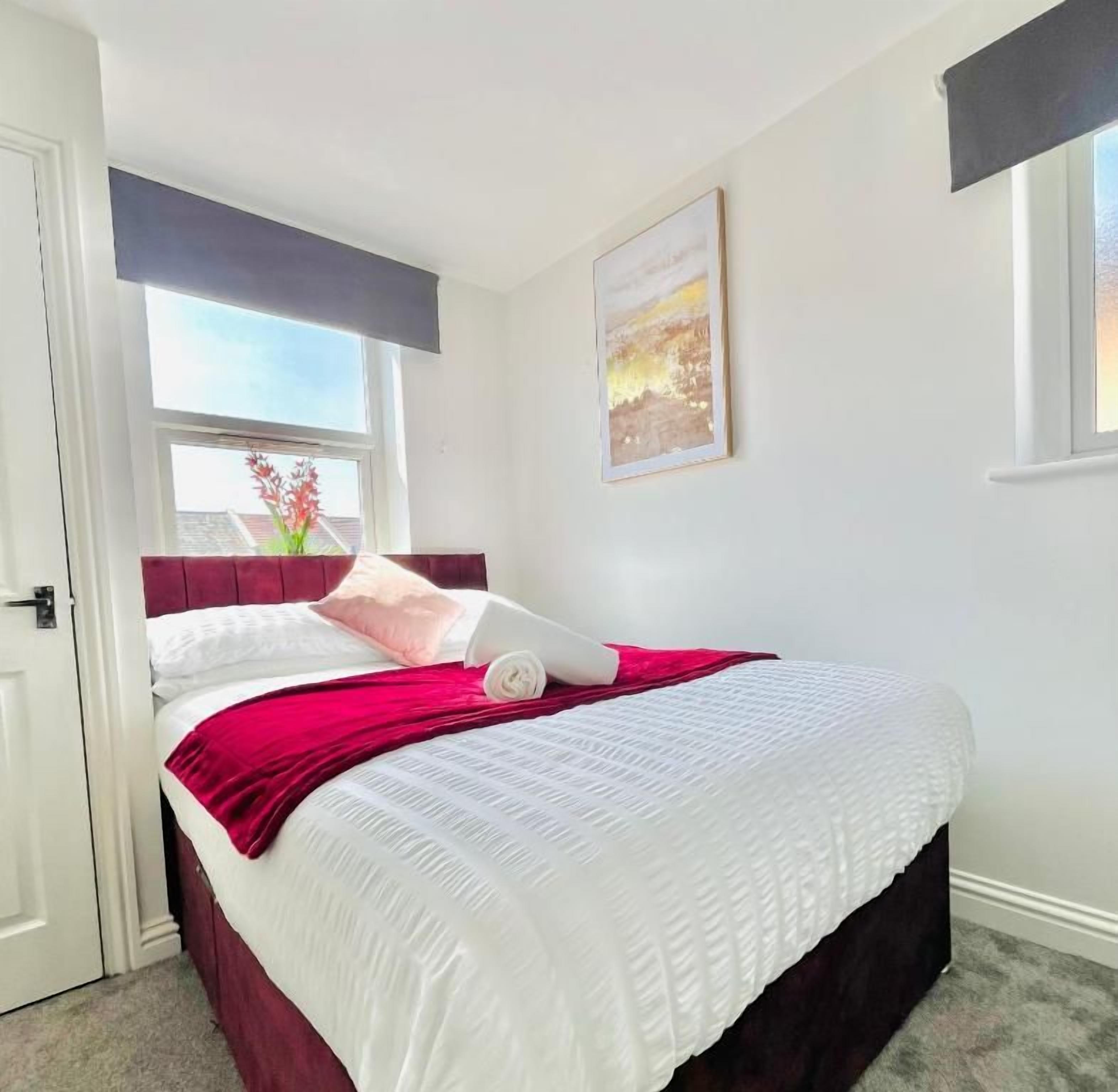 Un dormitorio con cama, ventana y un cuadro en la pared.