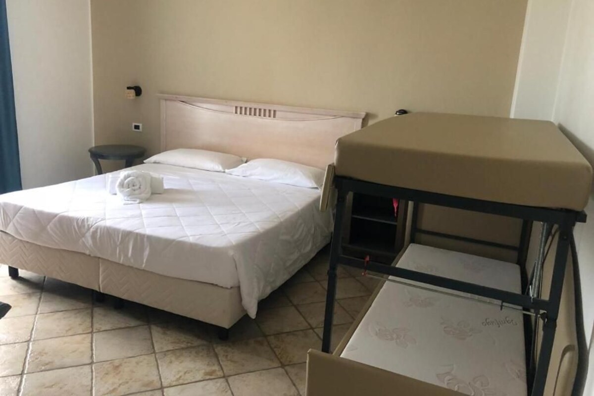 Habitació d'hotel amb un llit, una taula petita i una cadira.