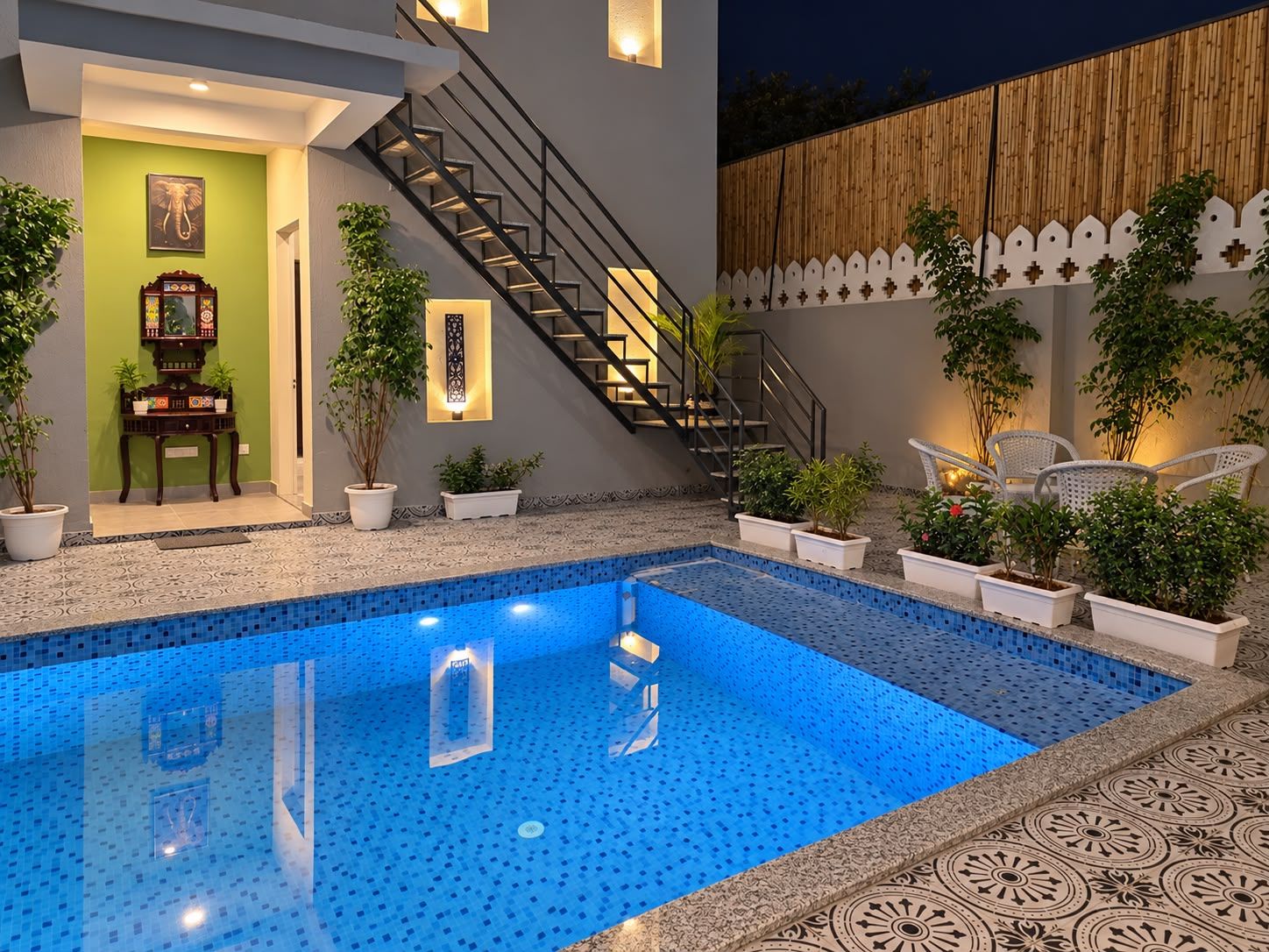 Una piscina con borde de azulejos, una escalera y plantas en macetas.