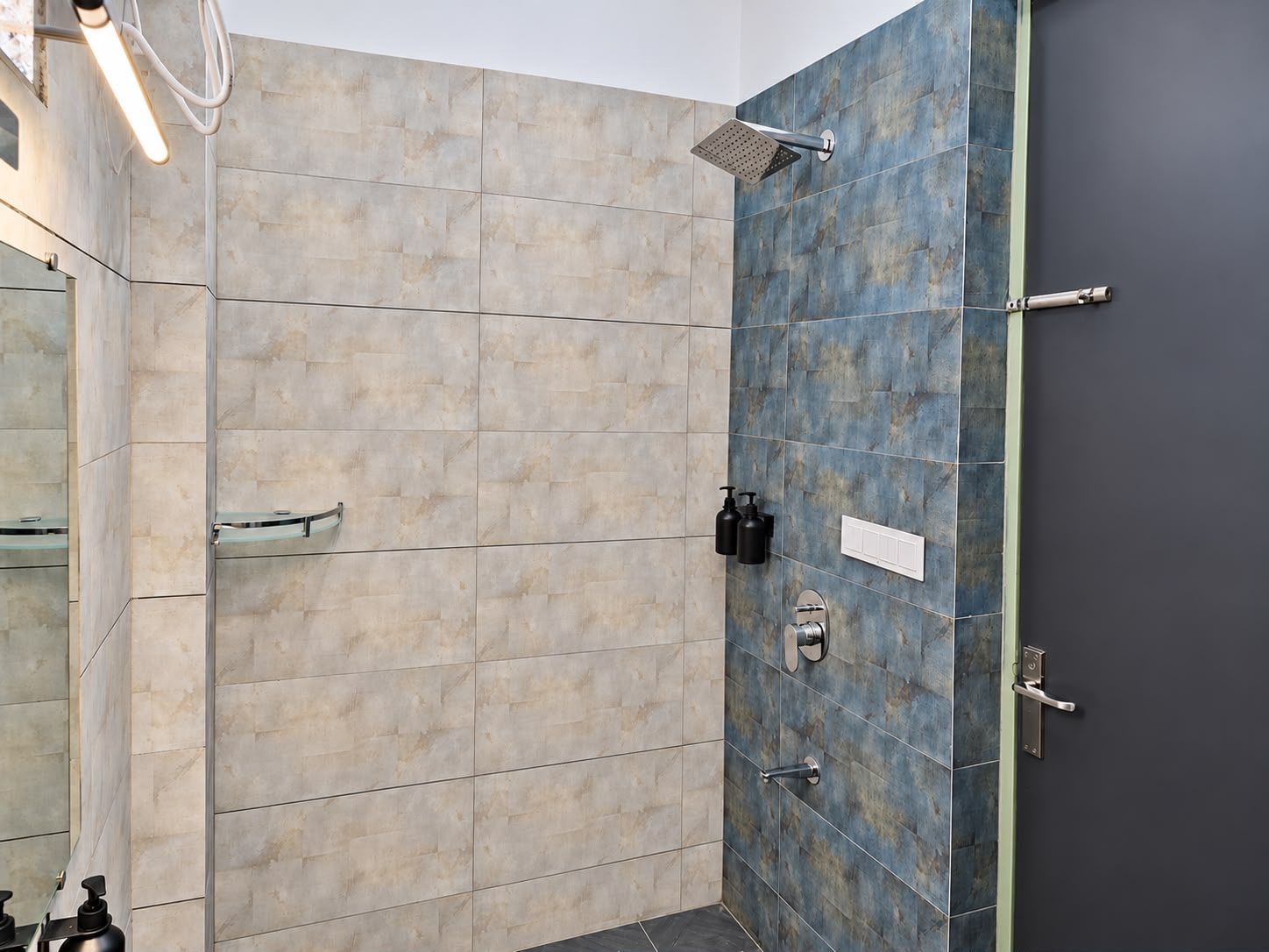 A bathroom with a shower, a mirror, and toiletries.