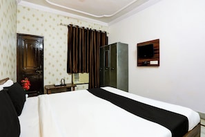 A hotel room with a bed, a wardrobe, a mirror, a television, and a small table with a kettle and cups. - Hotel O Gharaunda (Lucknow)