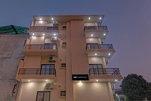 Un edificio de varios pisos con balcones, unidades de aire acondicionado y un letrero que dice 'OY TOWNHOUSE'.