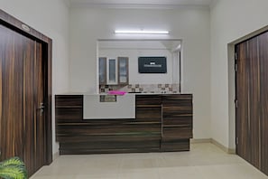 Una mesa de recepción con un cartel que dice 'OYO TOWNHOUSE' y una etiqueta que dice 'RECEPCCIÓN'.