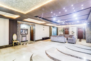 A spacious lobby with a marble floor, a reception desk, a sofa, and a door marked '201'. - Townhouse Sakura (Lucknow)