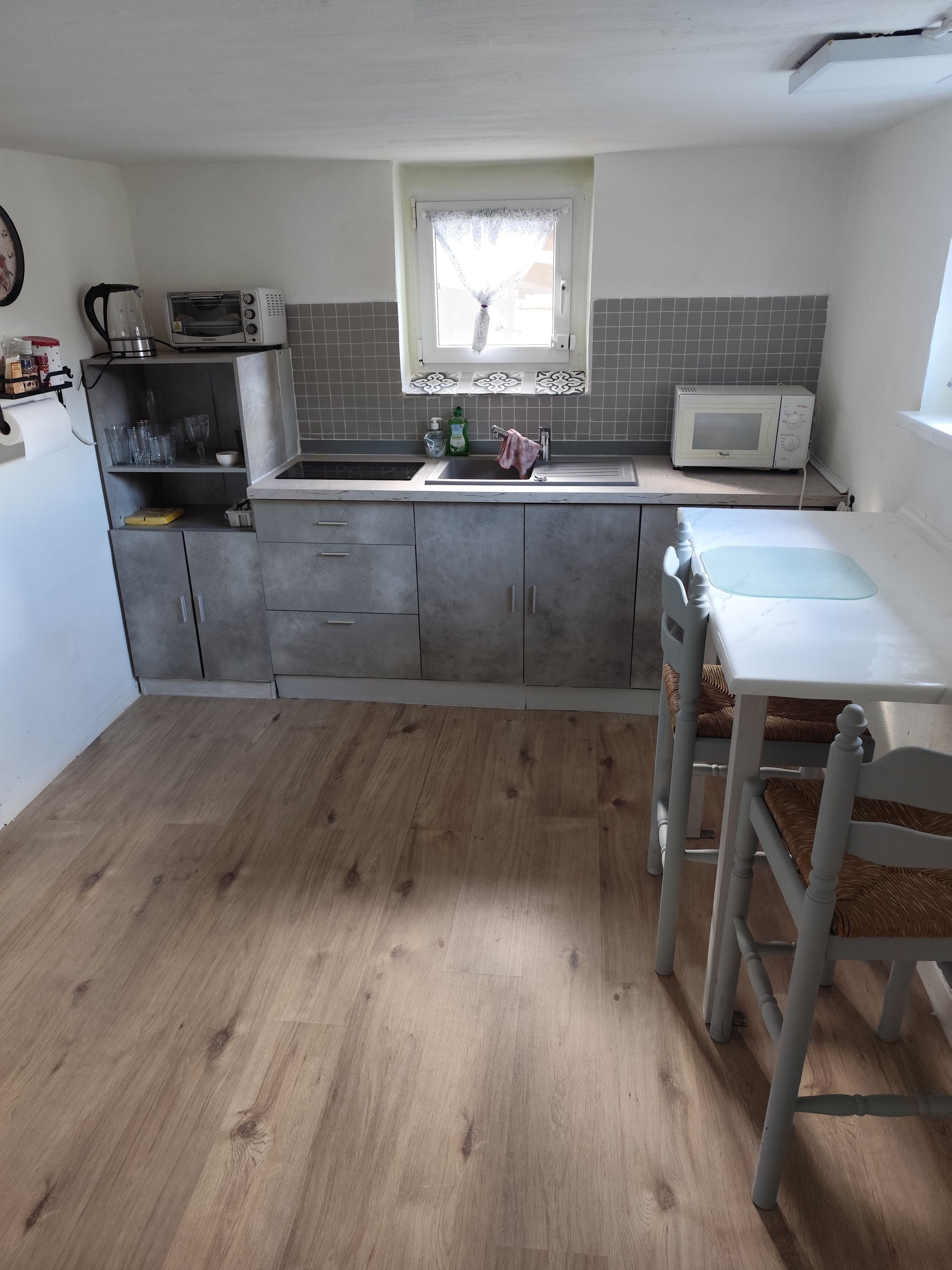 A kitchen with a built-in microwave, a sink, and a window above the countertop.