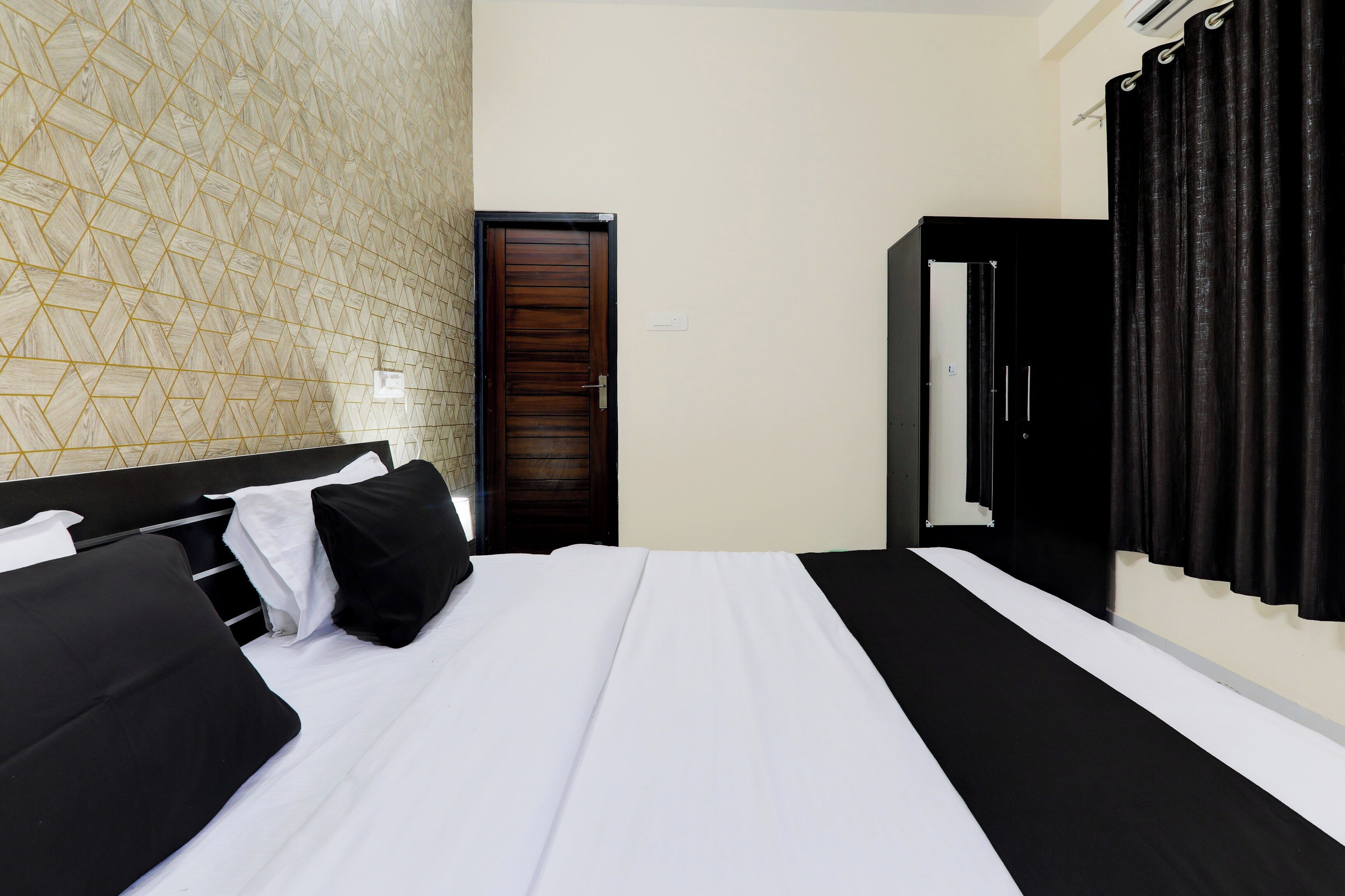 Habitación de hotel con cama, armario y puerta de baño.