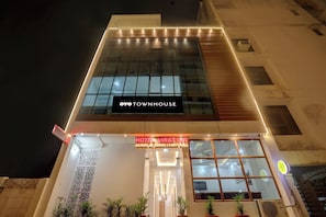 A hotel with a modern facade, a sign indicating it is a hotel and party hall, and a visible air conditioning unit. - Hotel O Virat Inn (Lucknow)
