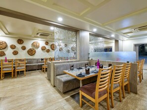 A restaurant interior with booths, tables, and a bar area. - Raga Inn Sasan Gir (Sasan Gir)