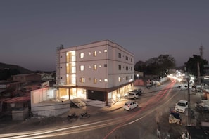 Um edifício de vários andares com telhado plano e uma escadaria central.