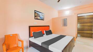 Een slaapkamer met een bed, een stoel, een schilderij en een raam.