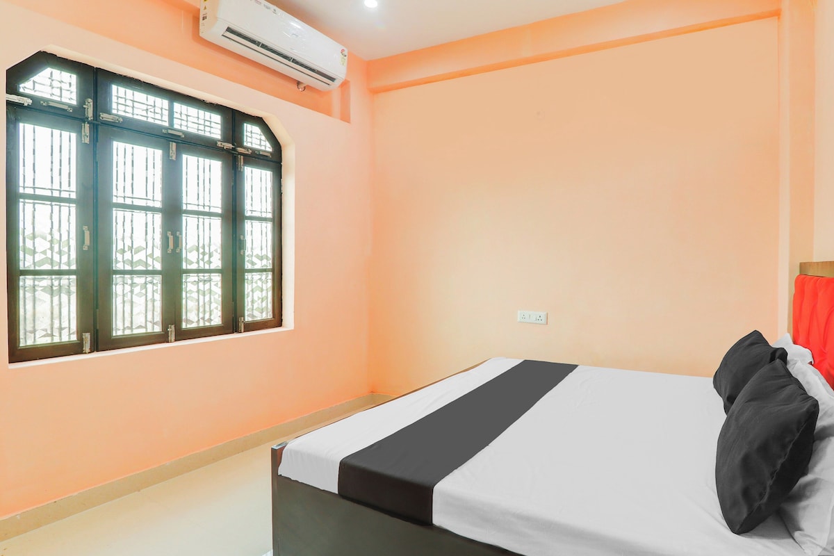 A room with a bed, a window, and an air conditioning unit.