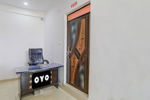 Een kamer met een houten deur, een bureau met een stoel en een bordje met 'OYO' erop.