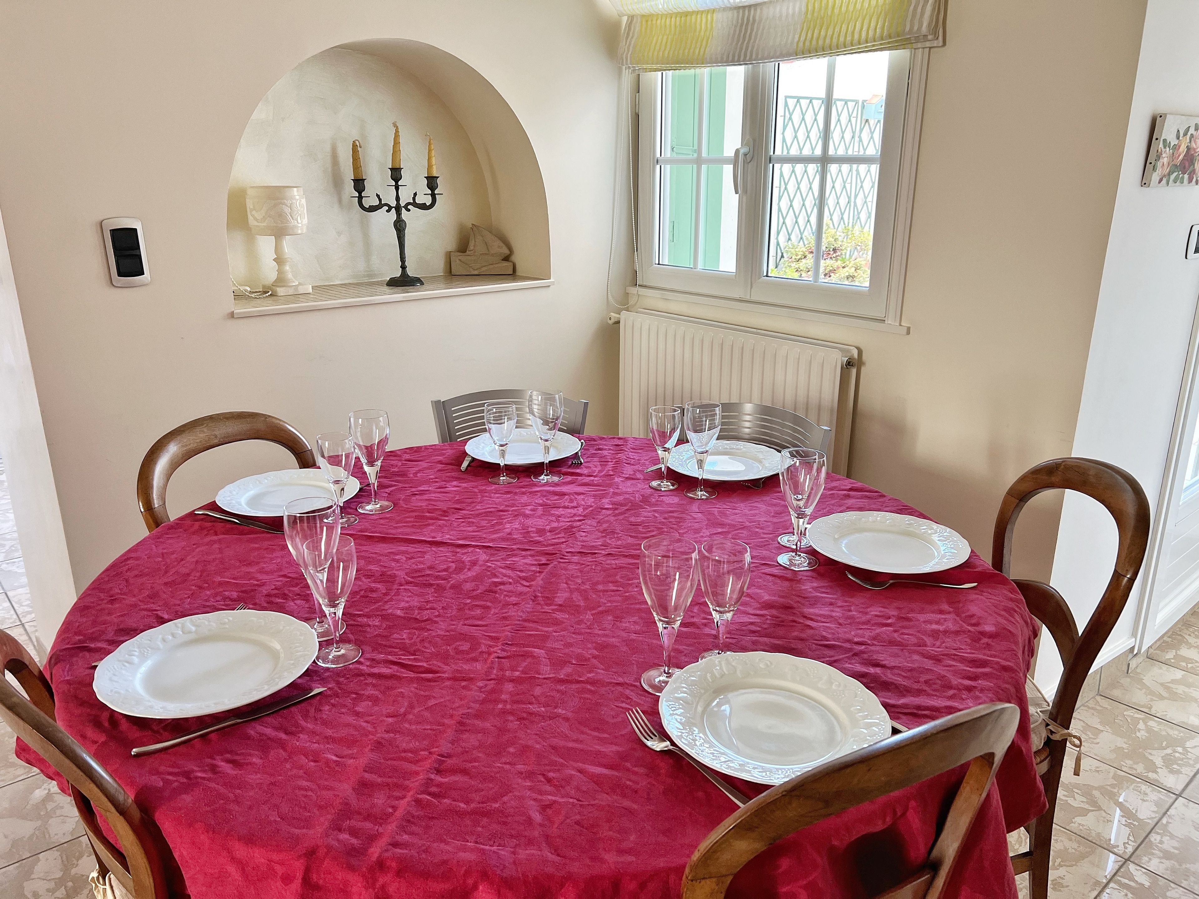 Een eethoek met een ronde tafel voor vier personen, omringd door houten stoelen.