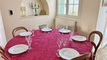 Een eethoek met een ronde tafel voor vier personen, omringd door houten stoelen.