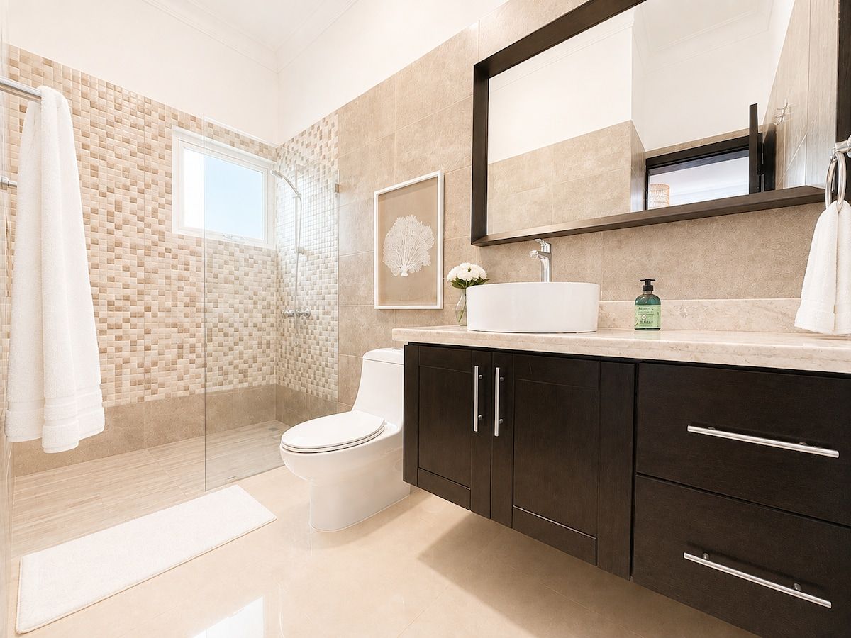 Un baño moderno con inodoro, tocador y zona de ducha.