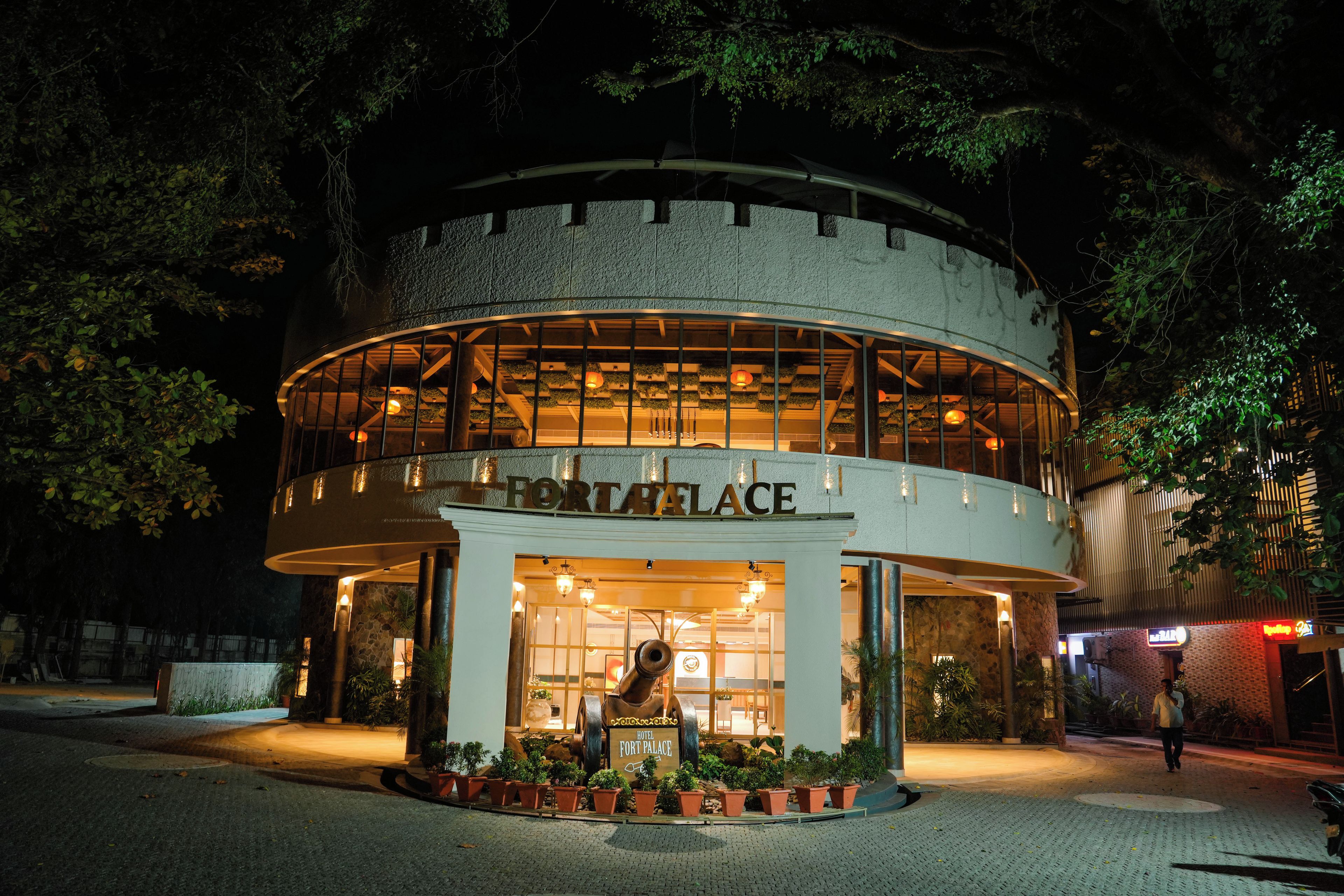 Un edificio circular con un cartel que dice 'FORT PALACE HOTEL' en la entrada.