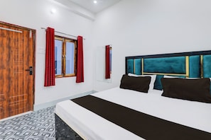 Een slaapkamer met een houten deur, een raam met rode gordijnen, een bed met een zwart-witte dekbedovertrek en een hoofdbord met turquoise kussens.