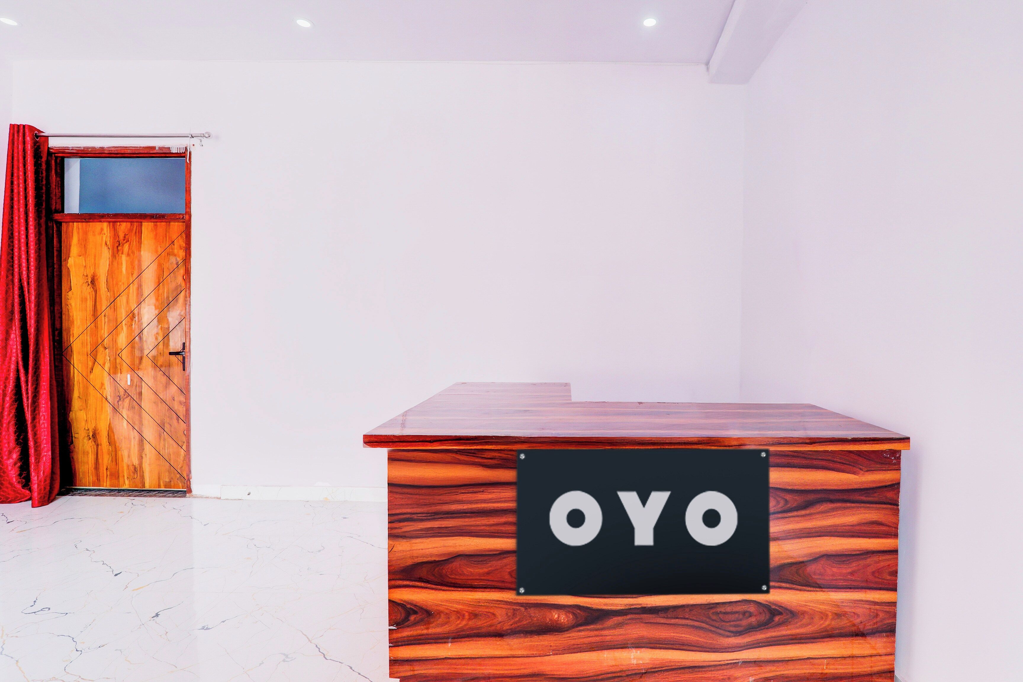 Een receptiebalie met een houten afwerking en een bordje met de tekst 'OYO'.