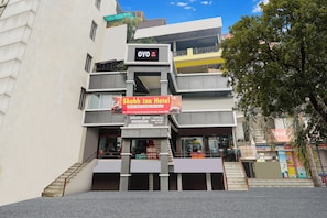 A hotel with a sign for Shubh Inn Hotel, a staircase, and a storefront with various items. - Hotel O Shubh Inn -2 (Lucknow)
