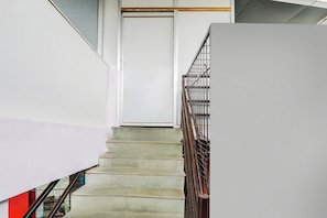 A staircase with a metal handrail and a door at the top. - Hotel O Shubh Inn -2 (Lucknow)