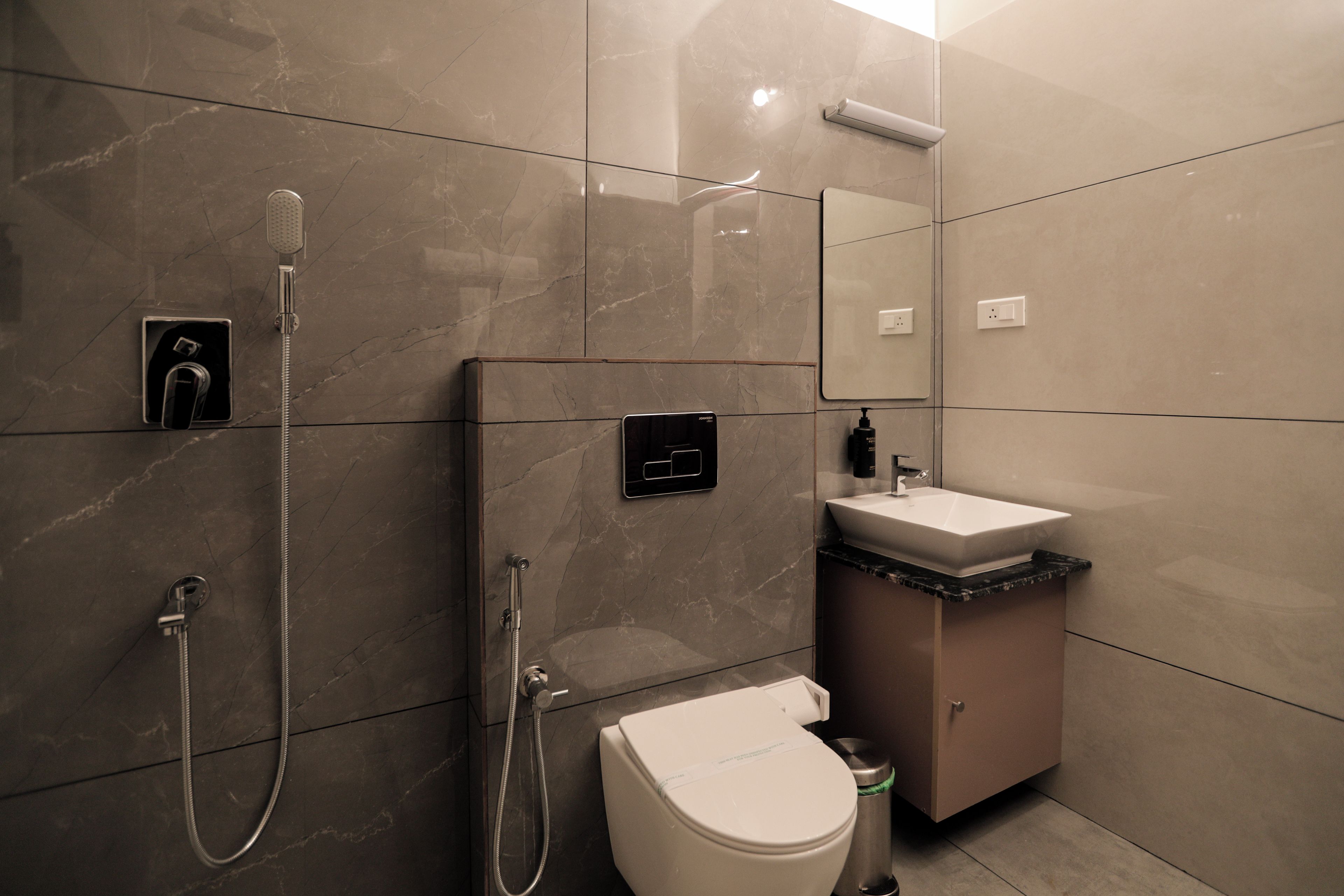 A modern bathroom with a toilet, sink, and shower.