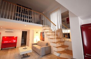A spacious living area with a staircase, a red refrigerator, and a modern sofa. - New Listing (Cava de' Tirreni)