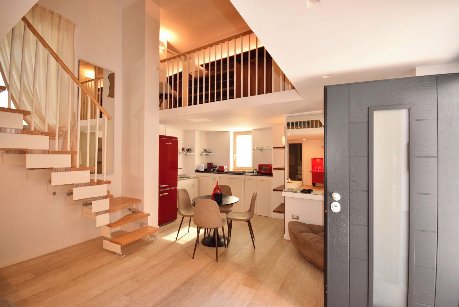 Un appartement moderne doté d’un escalier, d’un coin repas et d’une cuisine.