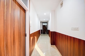 A hallway with wooden paneling on the walls and a tiled floor. - Hotel O Shubh Inn 4 (Lucknow)
