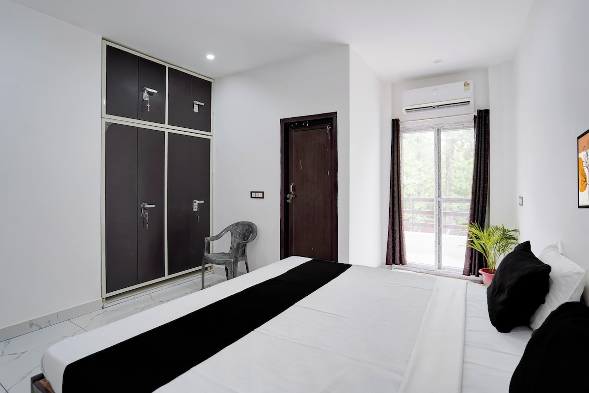 Een slaapkamer met een bed, een kledingkast, een stoel, een raam met gordijnen en een kamerplant.