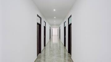 A long, narrow hallway with doors on both sides, leading to individual rooms.