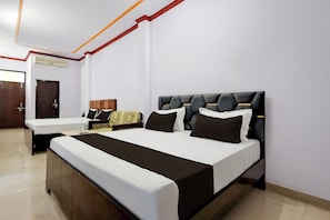 A hotel room with a large bed, a smaller bed, a wardrobe, and a door. - HOTEL O YASH ROYAL INN (Lucknow)