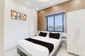 Un dormitorio con cama, armario y ventana con vistas.
