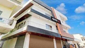 Un moderno edificio de hotel con un letrero llamativo que dice 'OYO Hotel Cozy Inn'.