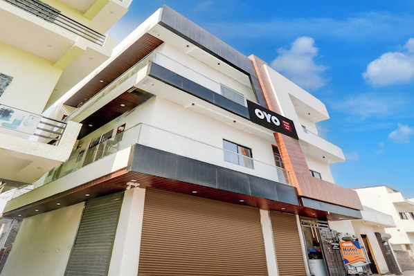 Un moderno edificio de hotel con un letrero llamativo que dice 'OYO Hotel Cozy Inn'.