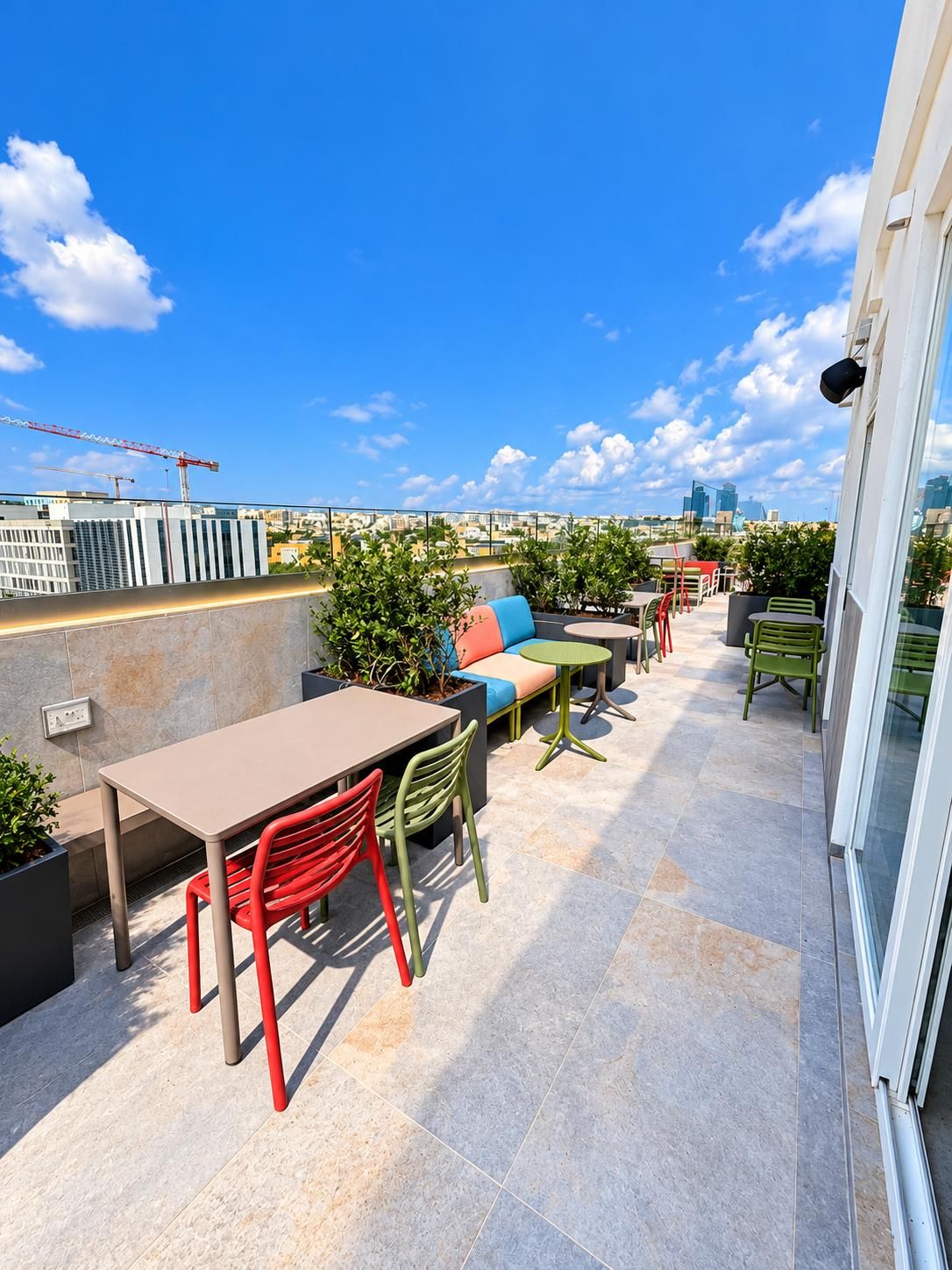 Une terrasse sur le toit, avec des sièges, une table et des chaises à l’extérieur.