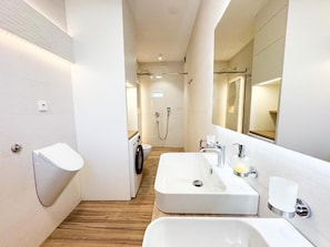 Une salle de bain moderne avec deux lavabos, des toilettes et une douche.