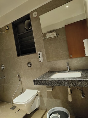 Un baño moderno con inodoro, bidé, lavamanos y toallero.