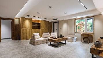 Una sala de estar moderna con un sofá modular, una mesa de centro de madera y vistas al exterior a través de un ventanal.