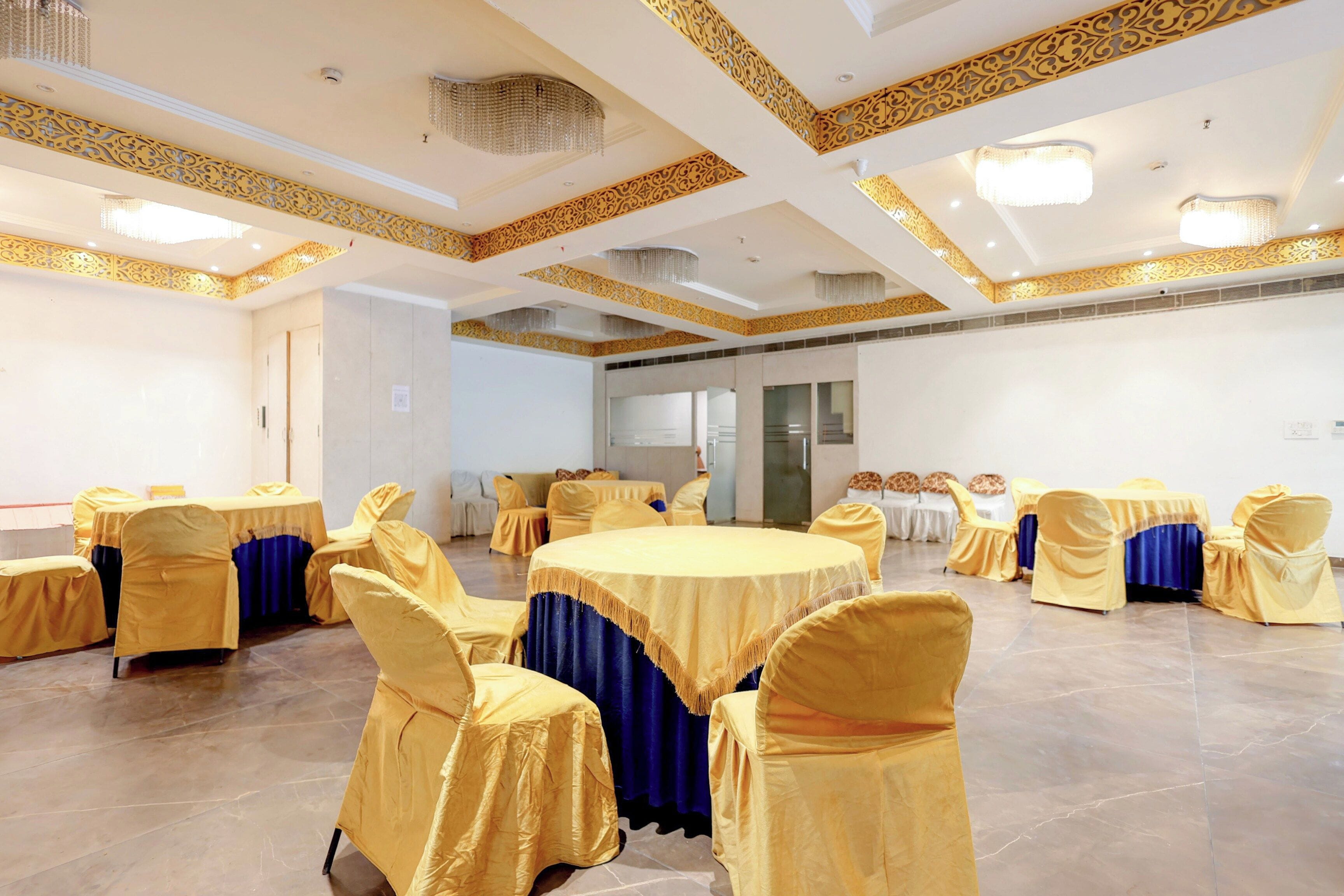 Une salle de conférence dotée de tables rondes, de chaises et d’un plafond décoratif.