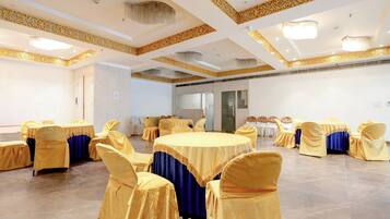 A conference room with round tables, chairs, and a decorative ceiling.
