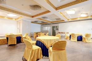 A conference room with round tables, chairs, and a decorative ceiling. - Hotel O Kingston House (Lucknow)