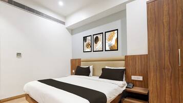 A modern bedroom with a large bed, wooden headboard, and a built-in wardrobe.