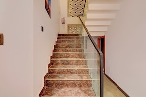 Un escalier avec des marches en marbre et une rampe en verre.