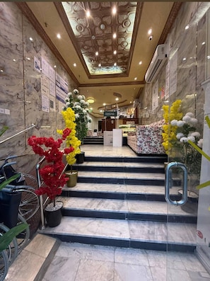 A hotel lobby with marble walls, a staircase, and a customer care desk. - Noor Al-Salam 2 Hotel, Gemmayzeh (Makkah Al-Mukarramah)