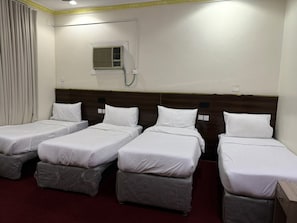 A hotel room with four single beds, a wooden headboard, an air conditioning unit, and a red carpet. - Noor Al-Salam 2 Hotel, Gemmayzeh (Makkah Al-Mukarramah)