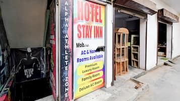 A hotel sign advertising various room types including a luxury room, family room, and deluxe AC room.