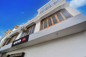A hotel building with a sign for 'OYO HOTEL STAY INN' and multiple windows with wooden frames. - HOTEL O STAY INN (Lucknow)