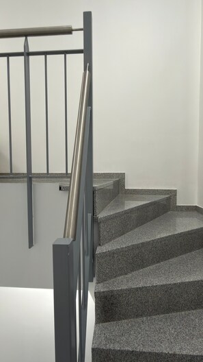 Eine Treppe mit Metallgeländer und Granitstufen.
